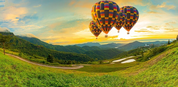 風船で山と空ドットインタノンで山の上を飛んでいるカラフルな熱気球
