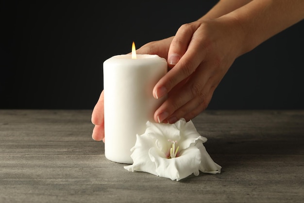 Foto candele in lutto in mano su uno sfondo scuro