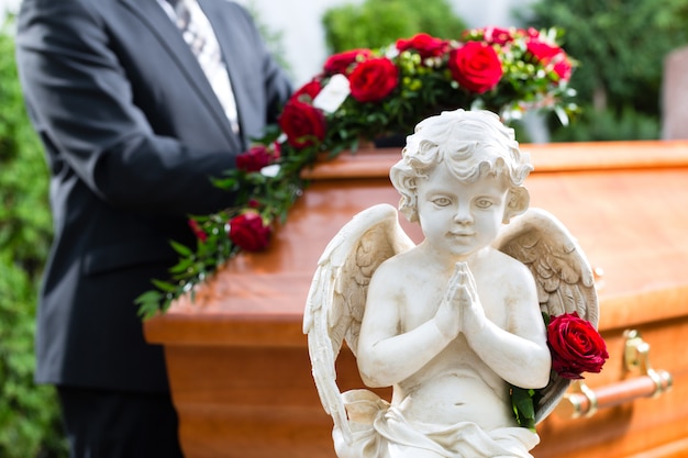 Photo mourning man at funeral with coffin