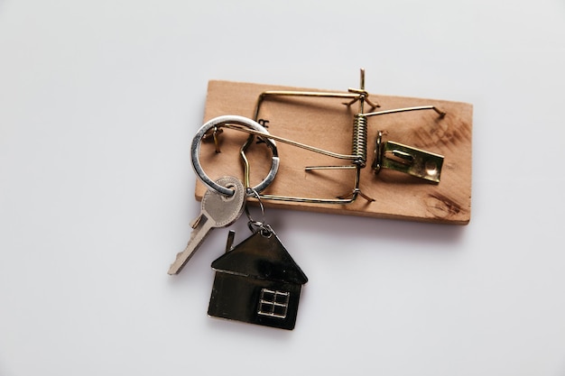 Фото Мышеловка с домом под ключ на белом фоне мошенничество или преступление в сфере недвижимости