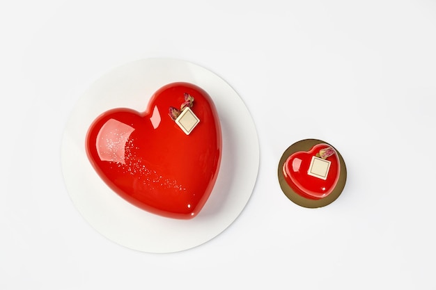 Mousse cake and pastry in shape of hearts with glossy red icing