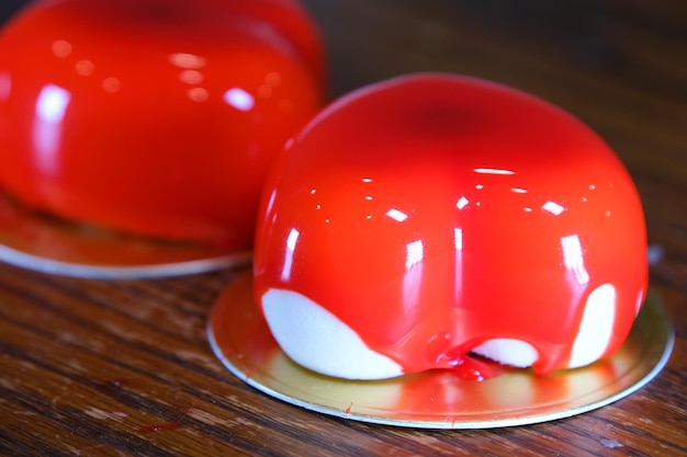 Mousse cake red pear caramel bright red mousse cake with strawberry decoration on a blue wooden back