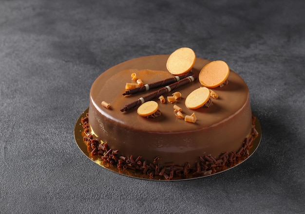 Mousse cake with chocolate and decor on dark gray background closeup