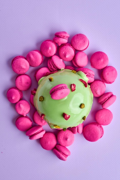 Mousse dessert on a pink background in a composition with small macaroons