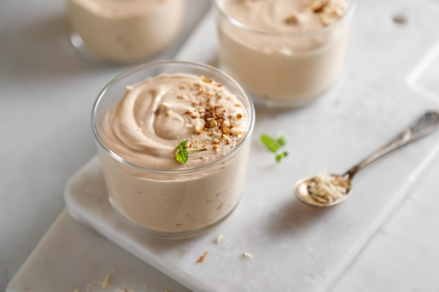 Mousse dessert with chocolate paste cheese and cream with nuts on the table and on the board