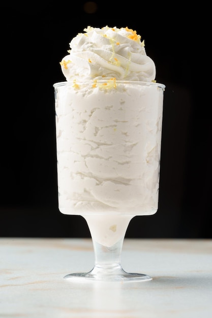 Mousse dessert with cream in glass on the table