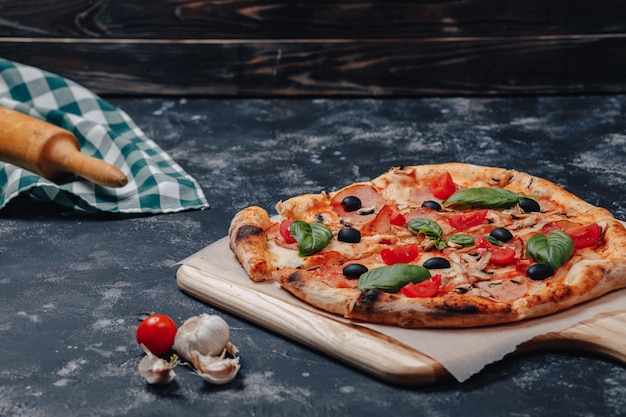 Mouth-watering Neapolitan pizza on a blackboard with various ingredients