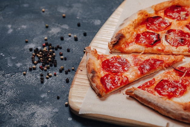 Mouth-watering Neapolitan pizza on a blackboard with various ingredients