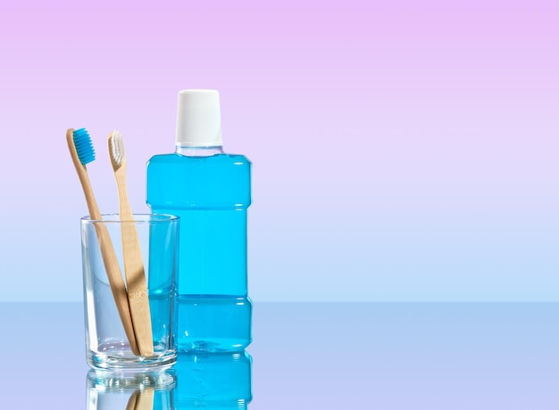 Mouthwash blue color for freshness and organic biodegradable toothbrushes in glass Copy space for text