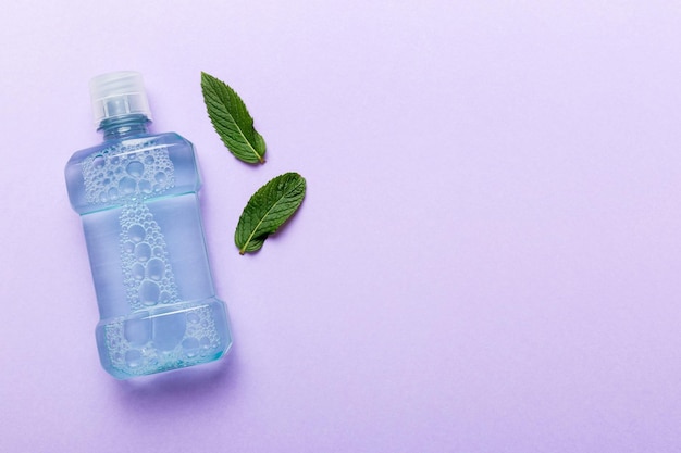 Mouthwash and fresh mint on colored background top view with copy space for text