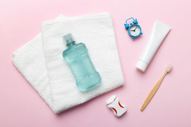 Mouthwash and other oral hygiene products on colored table top view with copy space Flat lay Dental hygiene Oral care products and space for text on light background concept