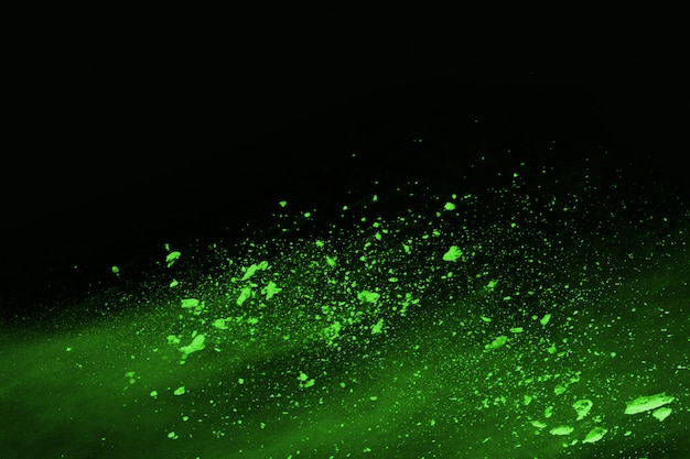 The movement of abstract dust explosion frozen green on black background. 