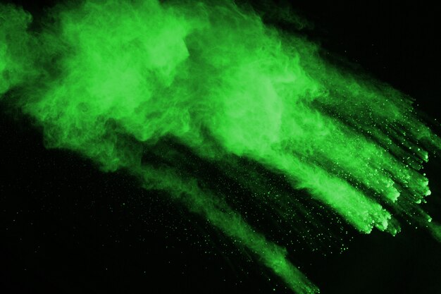 The movement of abstract dust explosion frozen green on black background. 