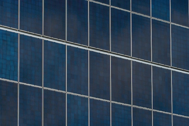 Movement of clouds against the background of a modern energyefficient building Multistorey residential building with solar panels on the wall Renewable energy in the city