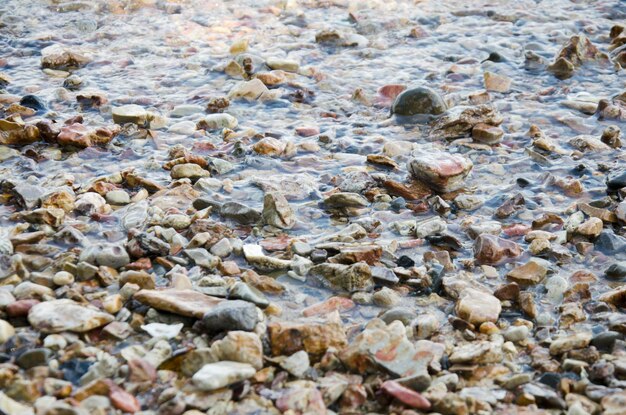 Movement of water wave in the sea with stone beach and shell at andaman ocean at Ko Yao Noi in Phang Nga Thailand