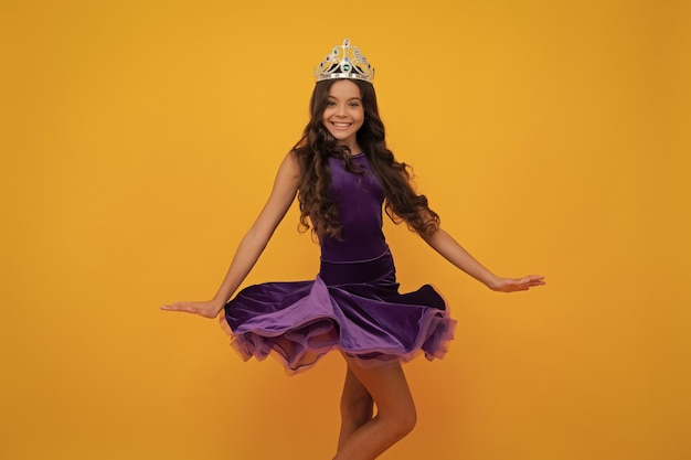 Movement windy dress Teenager princess child celebrates success win and victory Teen girl in queen crown Happy girl face positive and smiling emotions