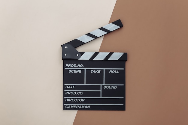 Movie clapper board on beige brown background. Filmmaking, Movie production, Entertainment industry. Top view