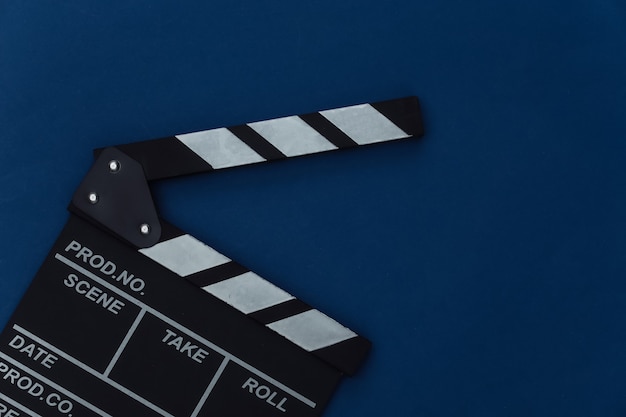 Movie clapper board on classic blue background. Filmmaking, Movie production, Entertainment industry. Color 2020. Top view