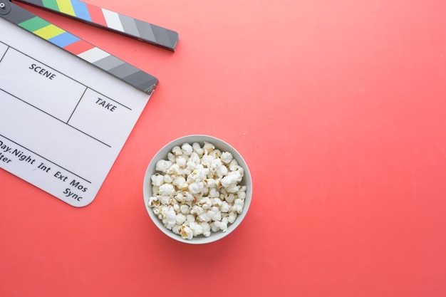 Movie clapper board and popcorn on table top view