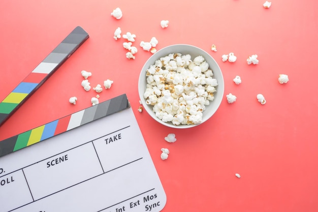 Movie clapper board and popcorn on table top view