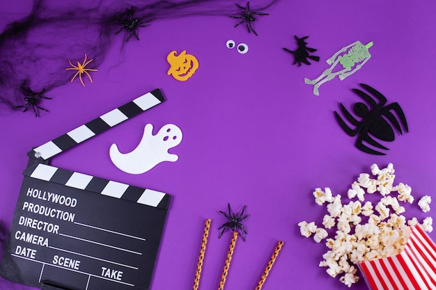 Movie clapper board in spider webs spiders ghost eyes on purple lilac background