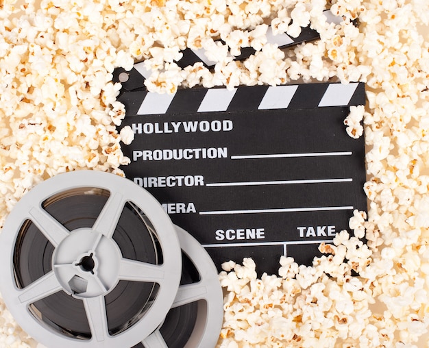 Movie clapper board surrounded by popcorns