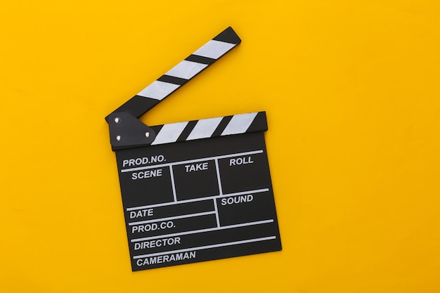 Scheda di valvola di film su sfondo giallo. produzione cinematografica, produzione cinematografica, industria dello spettacolo. vista dall'alto