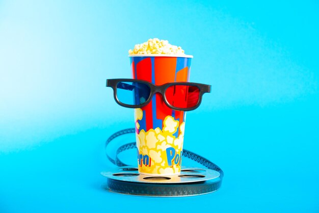 写真 映画のクラッパーポップコーン 3dメガネと青い背景のフィルムリール コラージュデザイン