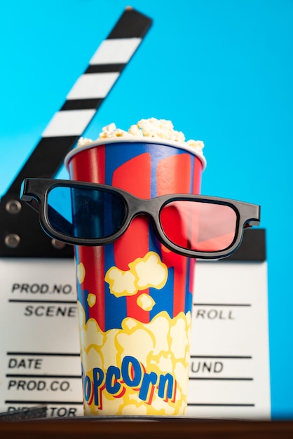 Movie clapper popcorn 3D-bril en filmrol op blauwe achtergrond Collage ontwerp