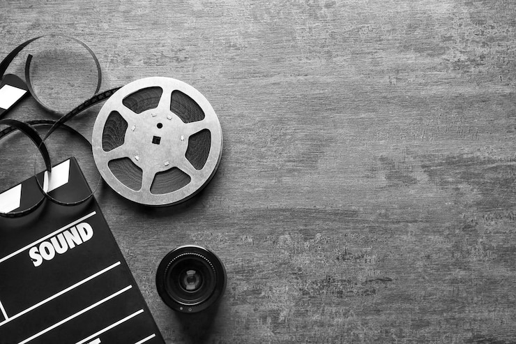 Photo movie clapper and reel on grey background top view