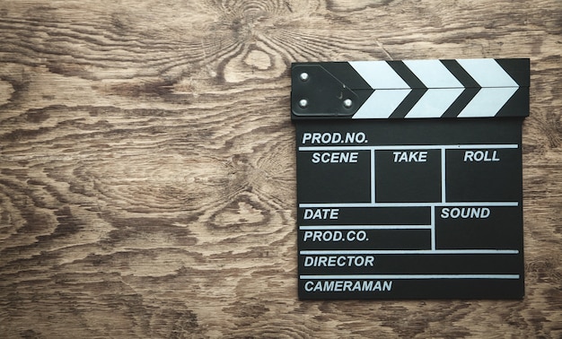 Movie clapper on wooden background.