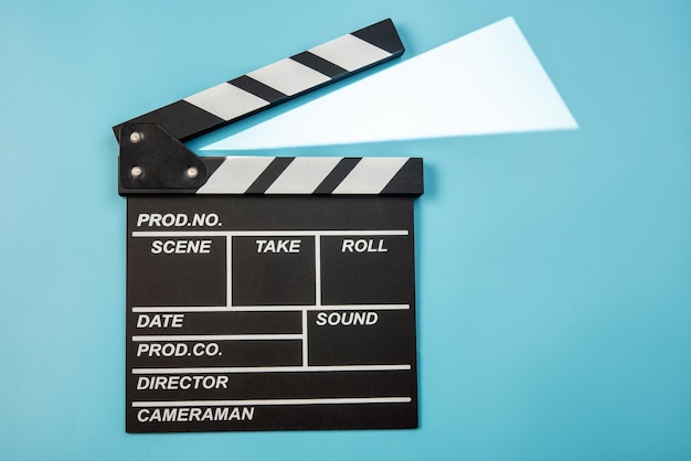 Movie clapperboard on blue background