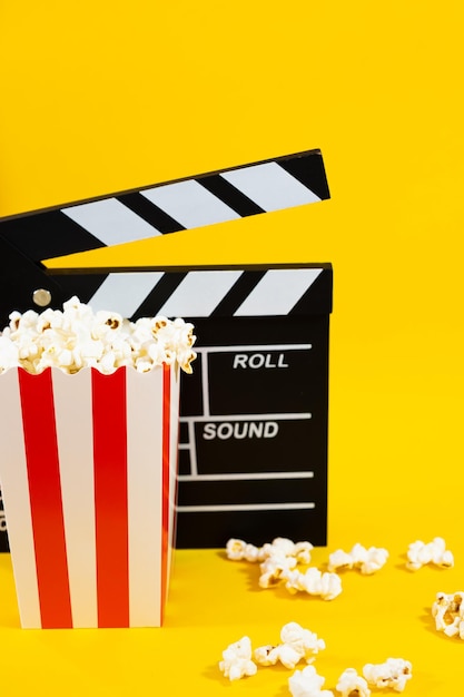 黄色い背景にポップコーンを貼った映画のクラッパーボード