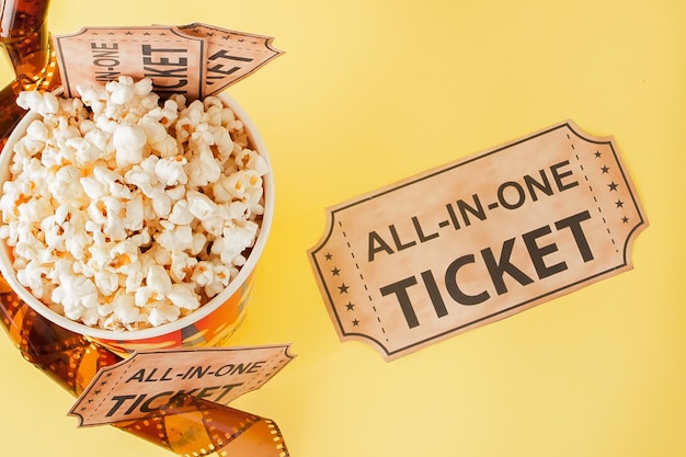 Movie tickets film strips and popcorn on blue background Copy space for text