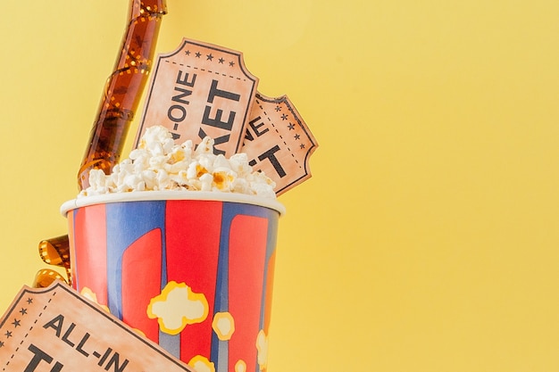 Movie tickets, film strips and popcorn on yellow