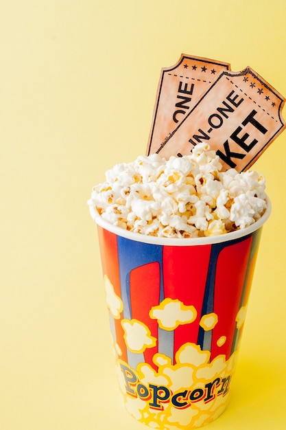 Movie tickets, film strips and popcorn on yellow
