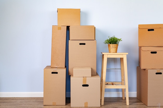 Движущиеся коробки с упакованными вещами и стулом для перемещения