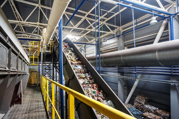 Moving conveyor transporter on modern waste recycling\
processing plant separate and sorting garbage collection recycling\
and storage of waste for further disposal