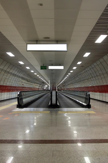 Foto scala mobile nella stazione della metropolitana passeggiata con cartellone pubblicitario vuoto situato nella sala sotterranea o nella metropolitana per il concetto di modello pubblicitario