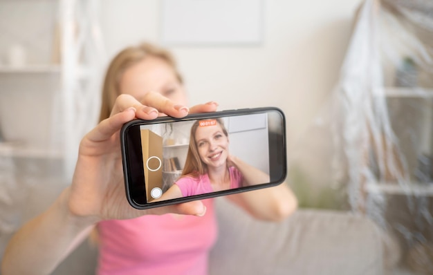 Moving home Joyful woman Lifestyle blog Happy lady on screen of smartphone shooting video in new light home interior blur