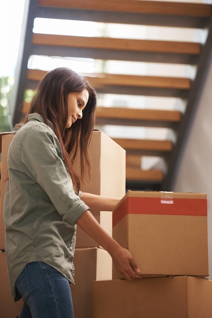 Moving to my new apartment Young woman setting a box down