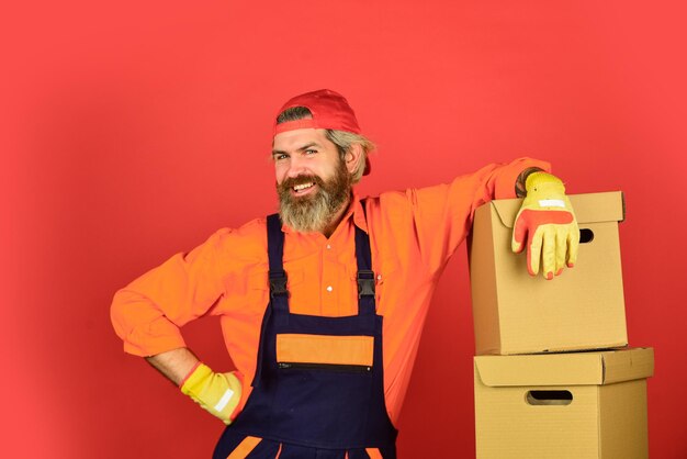 Moving to new apartment happy man cardboard box carrying boxes
inside building unpacking moving boxes new house at moving day
bearded man builder in boilersuit hold boxes