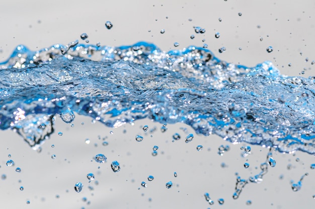 Moving water with droplets in studio with white background Spash