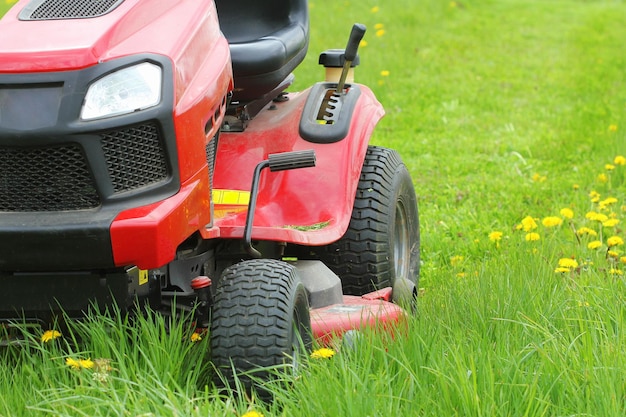 Photo mowing or cutting the long grass with a lawn mower gardening concept background