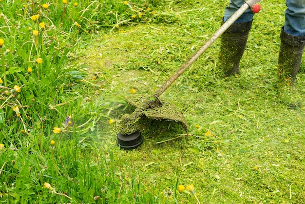 Mowing grass with a trimmer