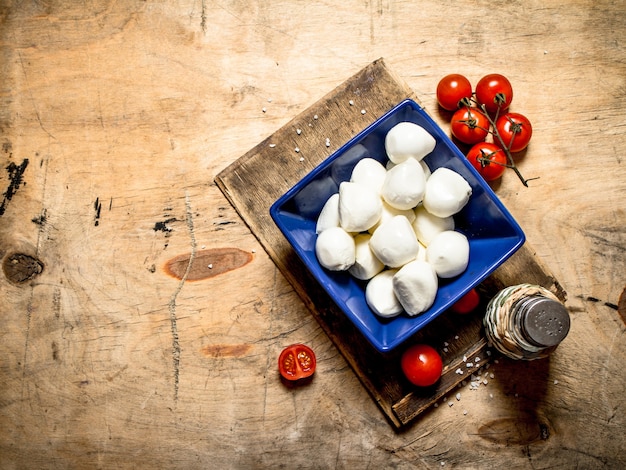 Mozzarella in a bowl with salt and tomatoes.