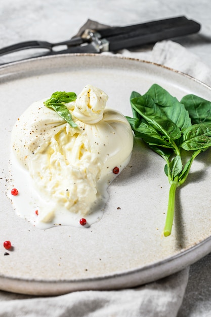 바 질 잎 하얀 접시에 모 짜 렐 라 Burrata 치즈. 회색 배경. 평면도