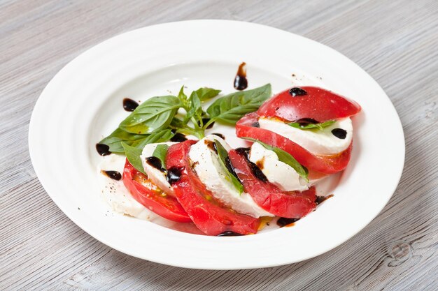 Mozzarella cheese and tomato with basil leaves