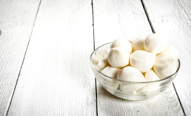 Mozzarella in de schaal op een witte houten achtergrond