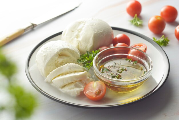 Mozzarella-kaas en kersentomaten met kruiden. Zelfgemaakte mozzarella-kaas.